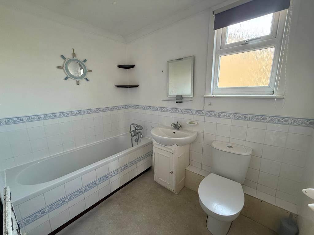 Lot: 141 - DETACHED FOUR-BEDROOM HOUSE FOR IMPROVEMENT - Tiled bathroom with window, bath and basin